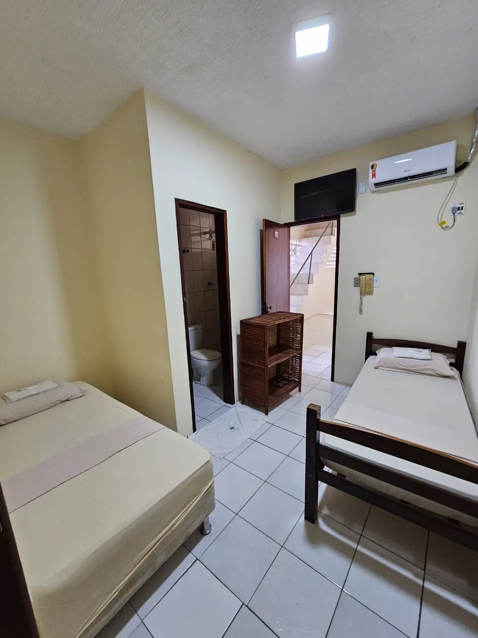 Quarto com duas camas de solteiro, TV e ar-condicionado